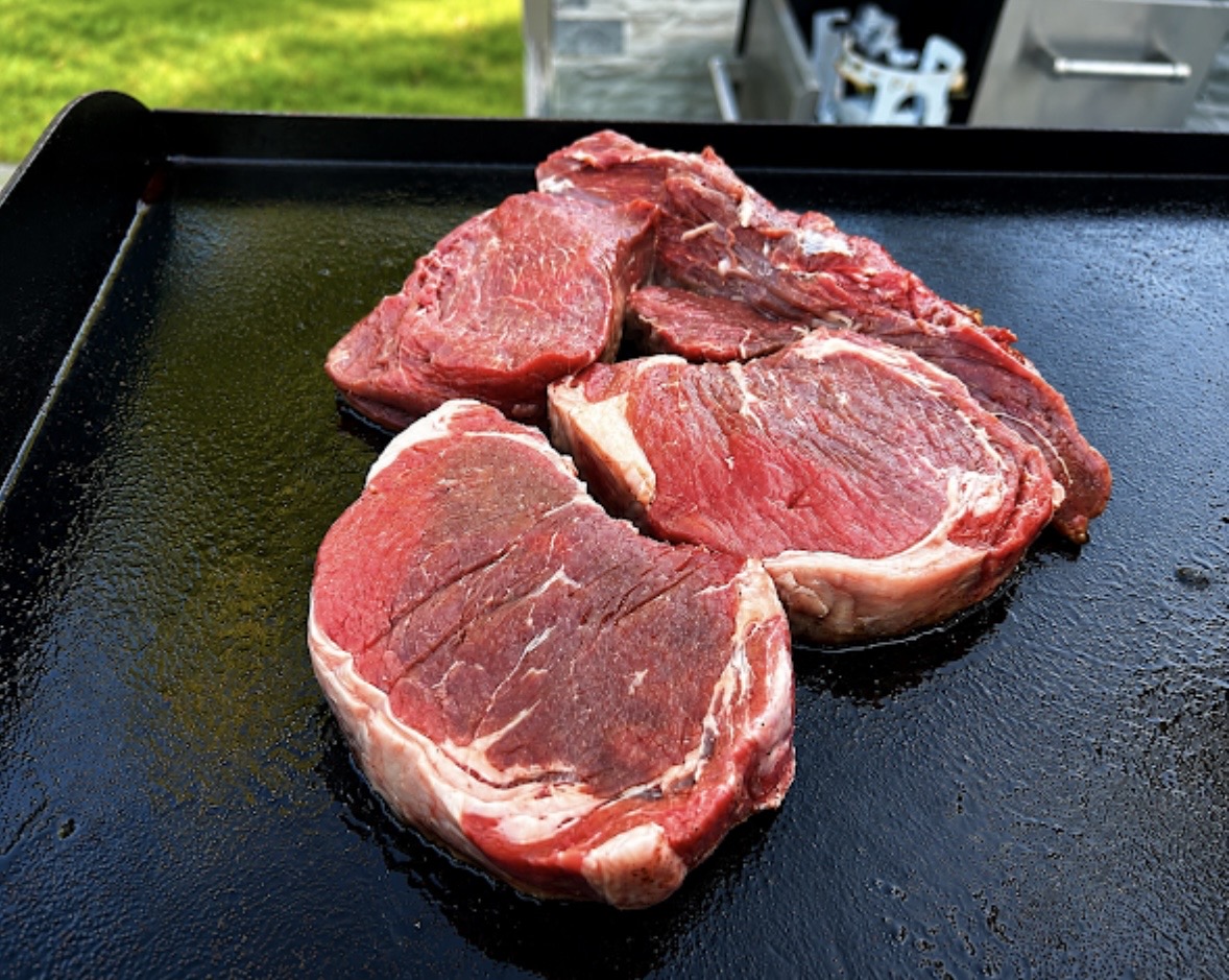 Thick-cut grass-fed steaks resting on the hibachi griddle