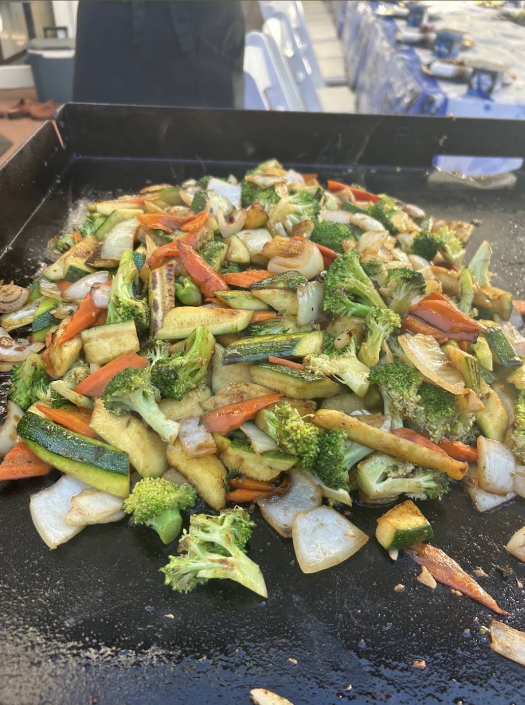 Zucchini, broccoli, carrots and onion stir-fried on the griddle